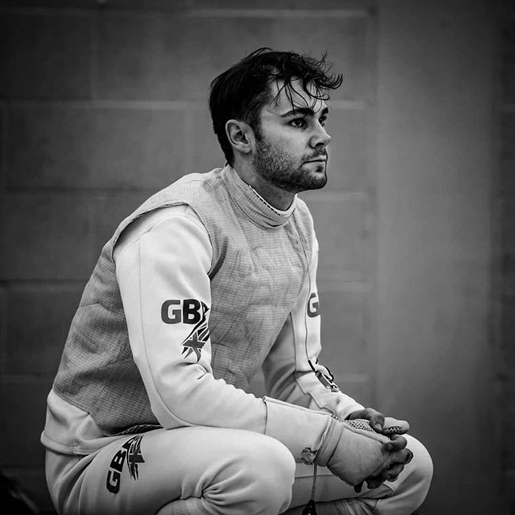 Josh Burn, GBR foilist, seated before a bout